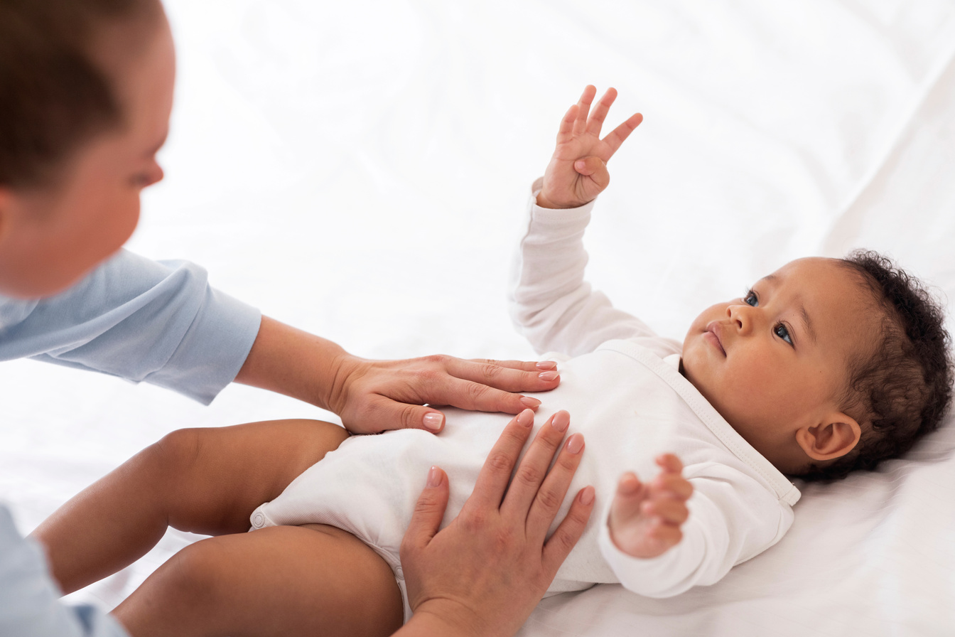 Masseur Massaging the Tummy of a Baby